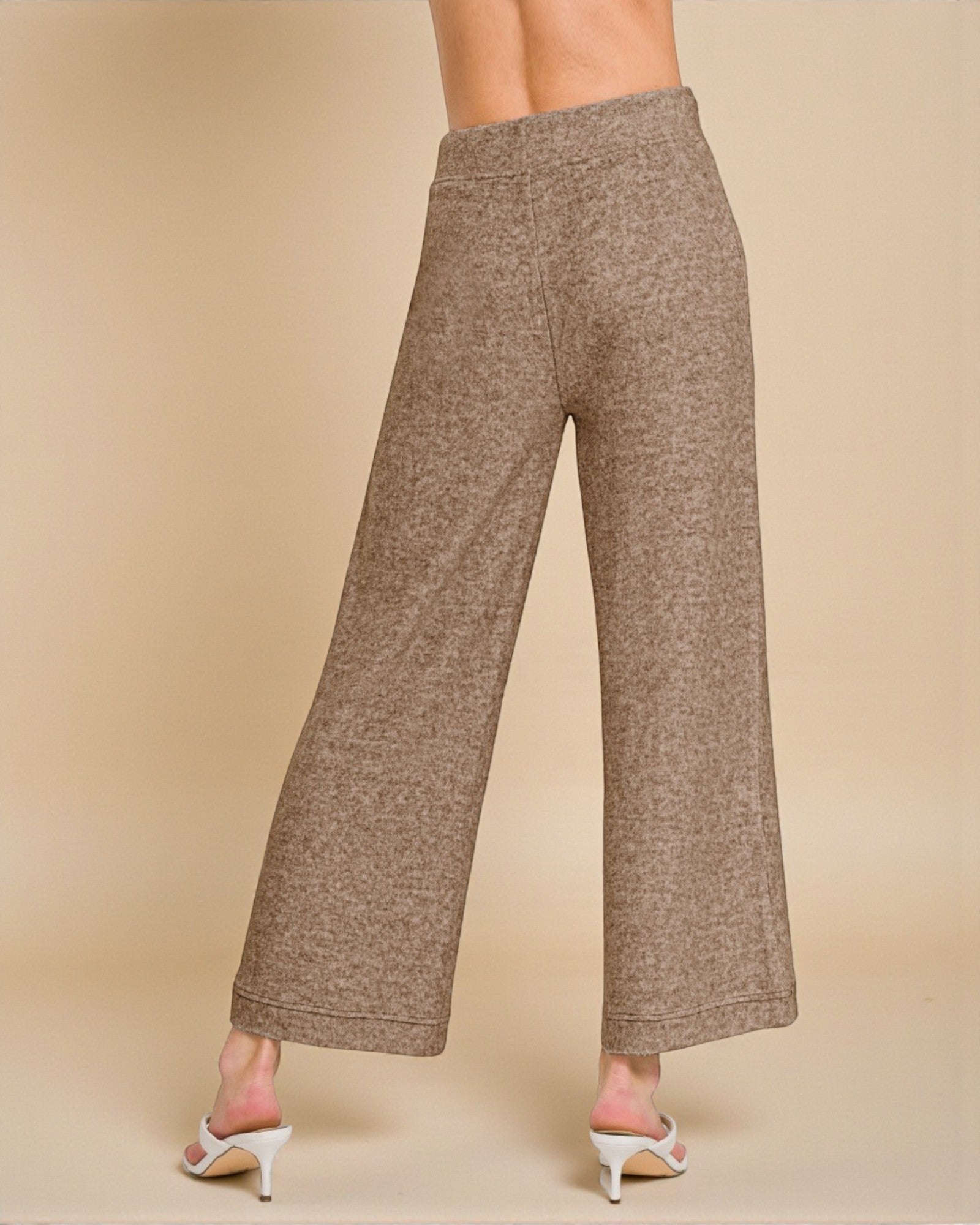 Brown wide-leg pants worn by a person on a beige background