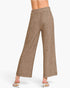 A person shown from the waist down wearing high-waisted, wide-leg cropped pants in a heathered taupe-brown color, paired with white heeled sandals against a plain light gray studio background.