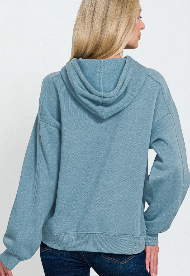 Person wearing a light blue hoodie on a white background
