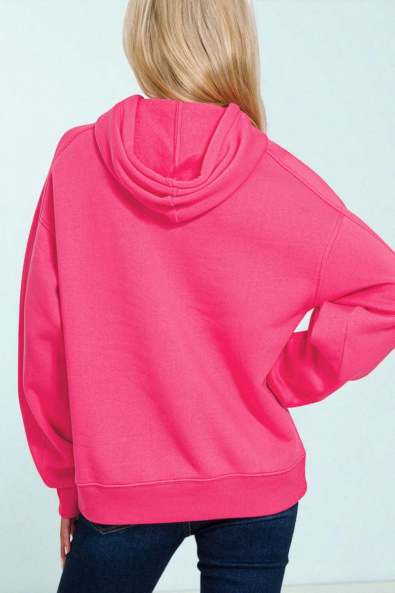 Person wearing a bright pink hoodie against a light background