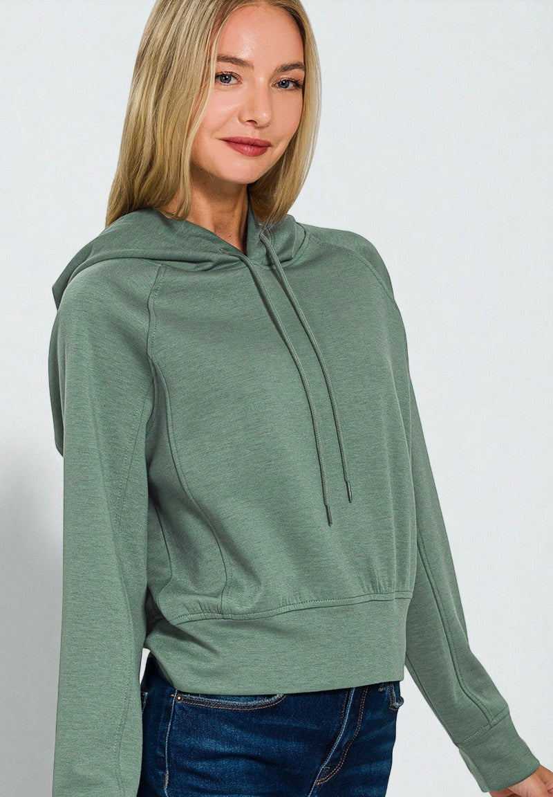 Woman wearing a green hoodie against a white background
