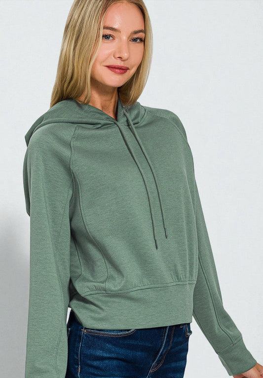 Woman wearing a green hoodie against a white background