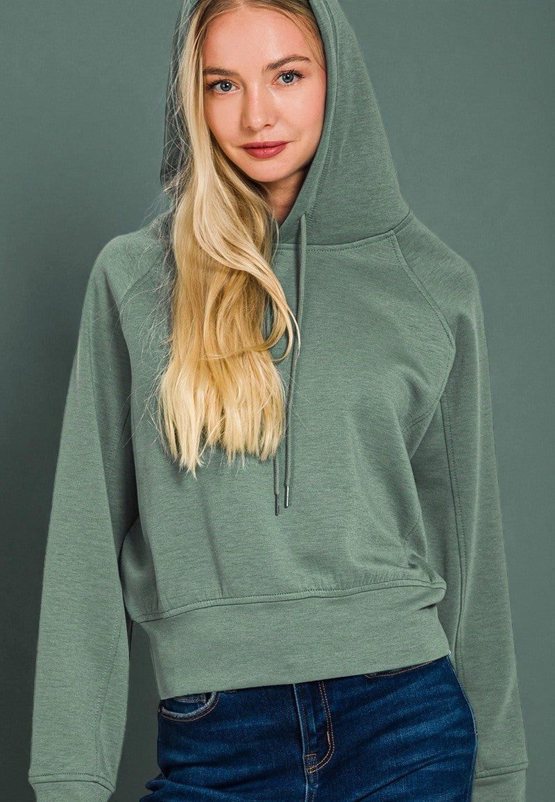 Person wearing a green hoodie against a gray background