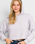 Woman wearing a light gray hoodie against a plain background