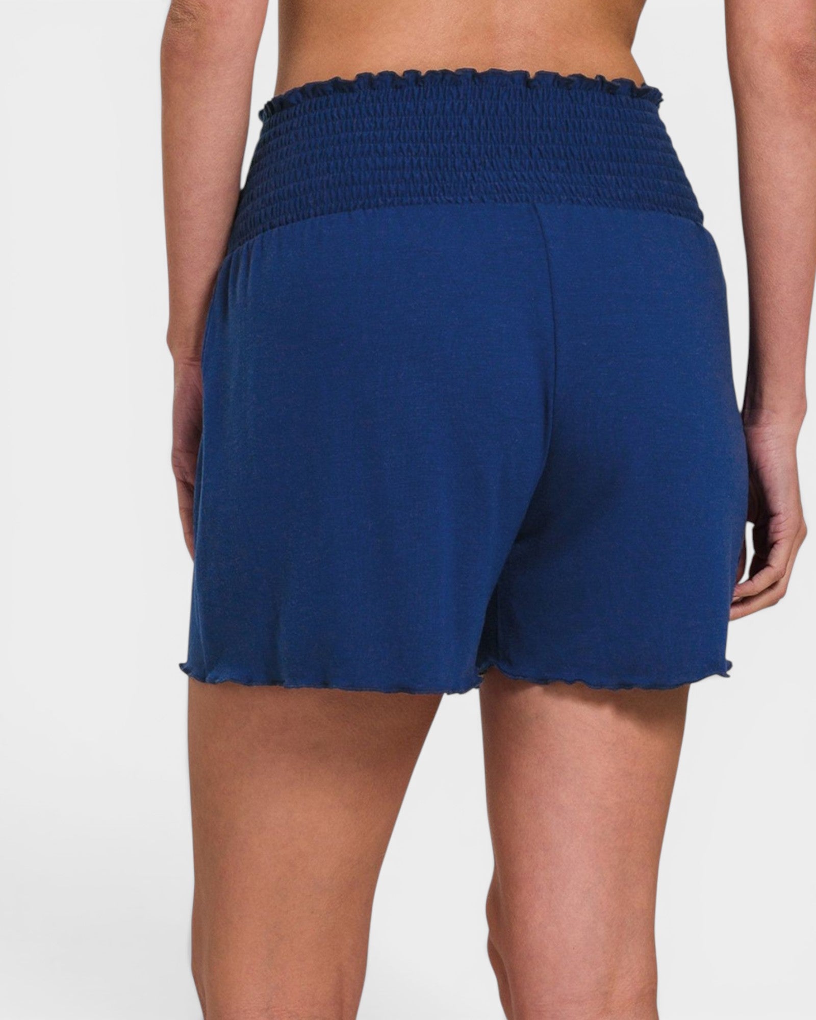 Blue shorts worn by a person on a white background