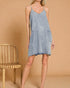 Woman wearing a denim dress against a beige background