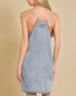 Light blue denim dress with thin straps on a beige background