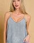 Woman wearing a light blue camisole against a beige background