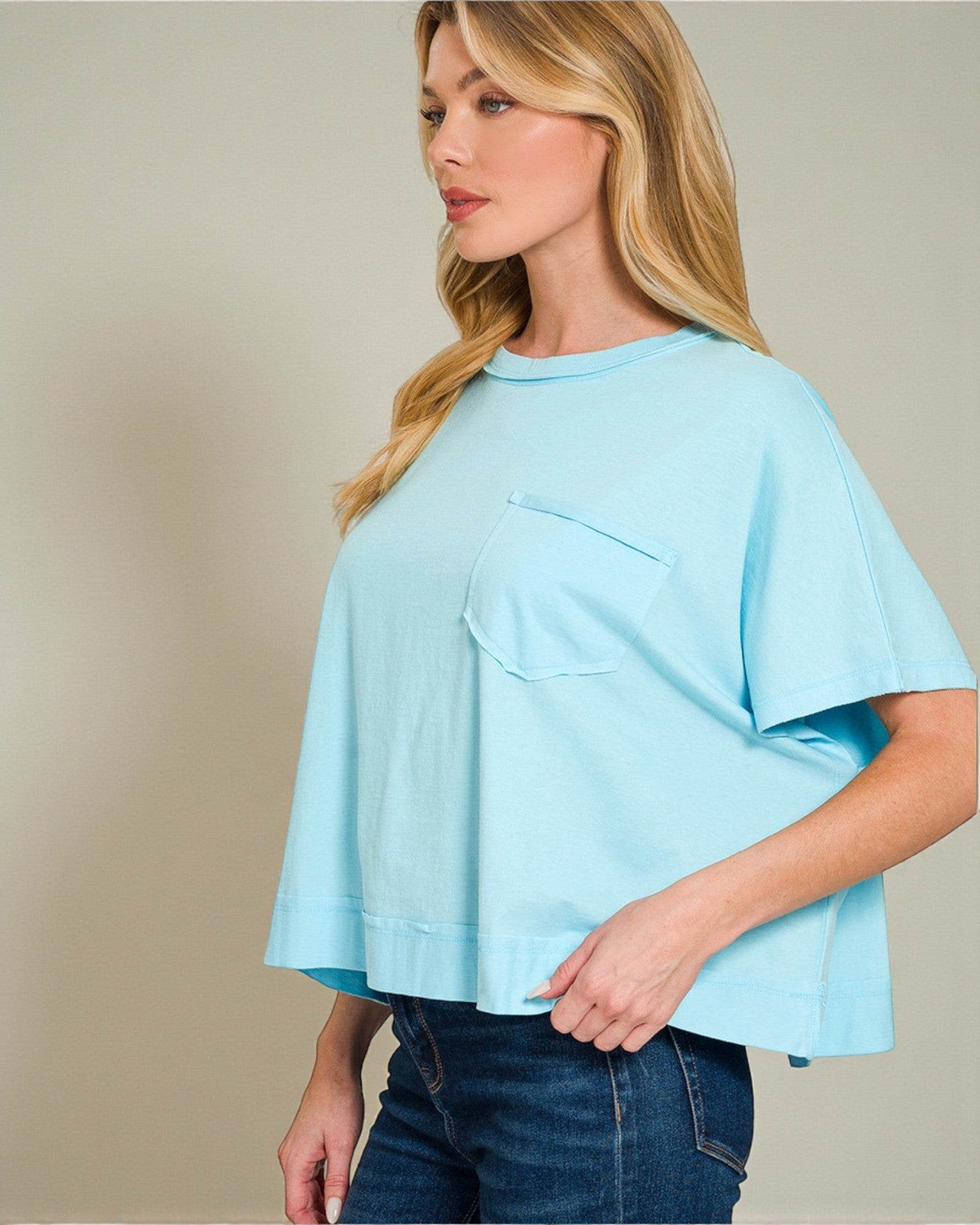 Woman wearing a light blue top with a plain background