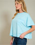 Woman wearing a light blue top with a plain background