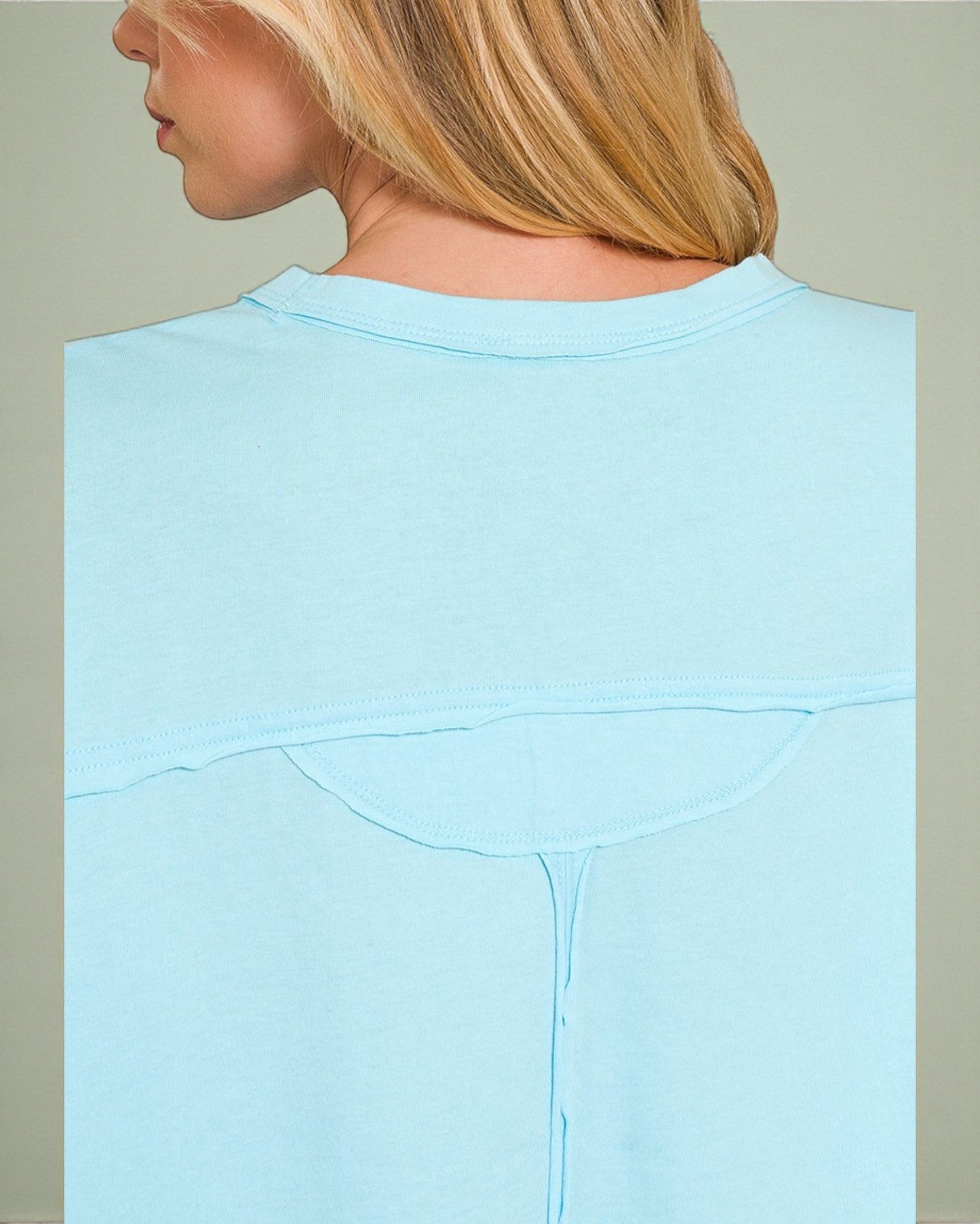 Light blue sweatshirt worn by a person with a neutral background