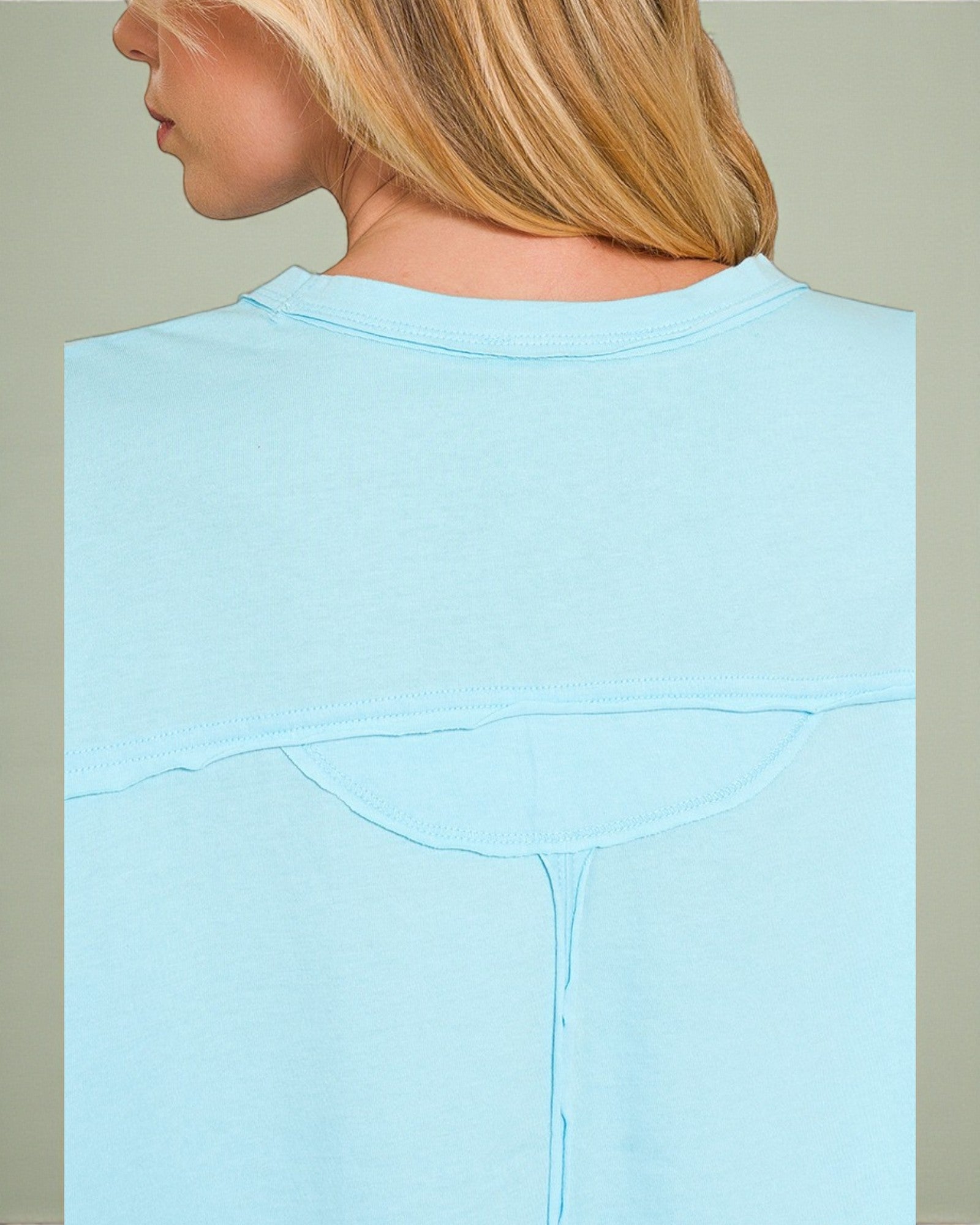 Light blue sweatshirt worn by a person with a neutral background