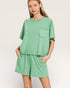 Woman wearing a green outfit with a plain background