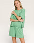 Woman wearing a green outfit on a plain background