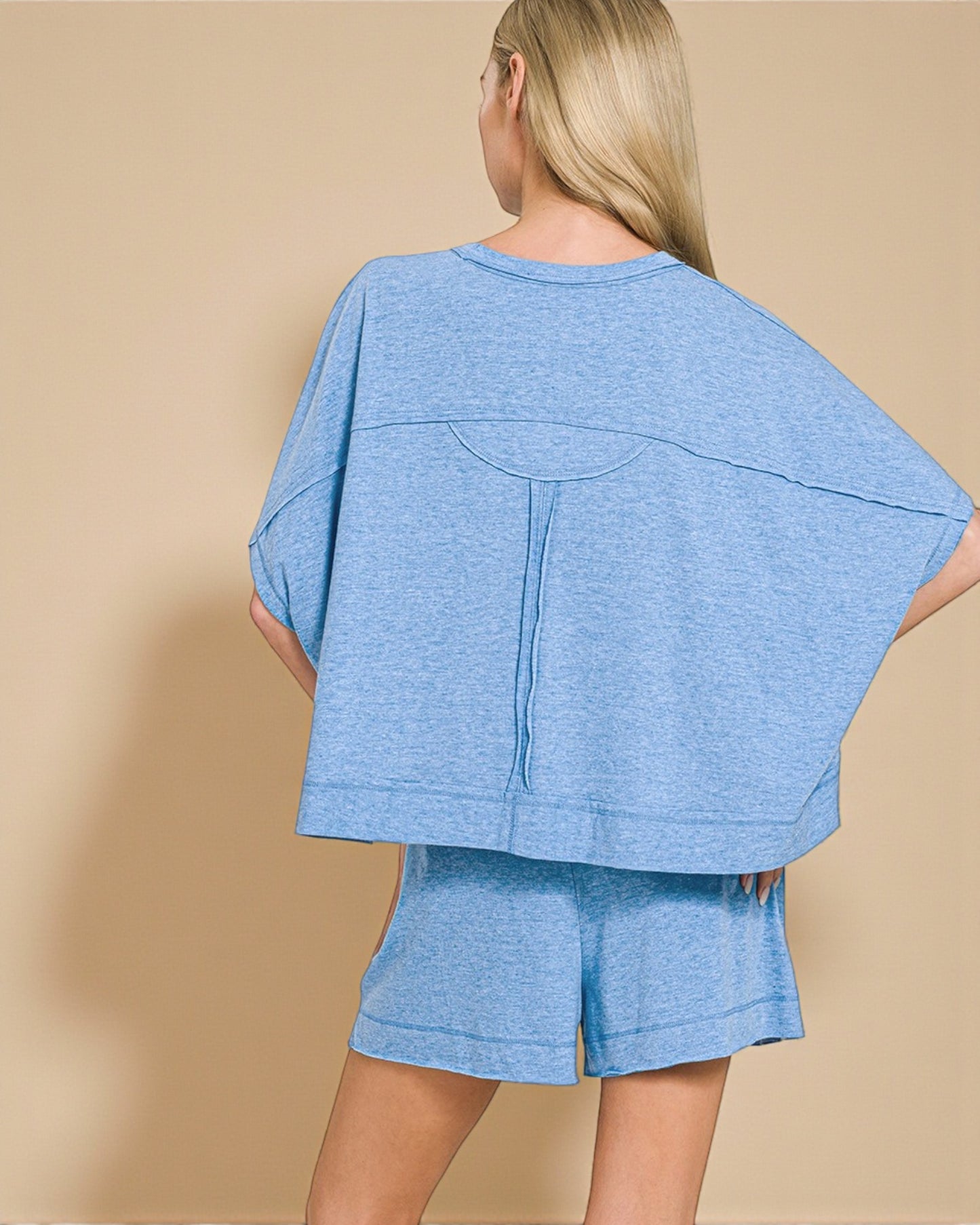 Woman wearing a blue outfit with a beige background