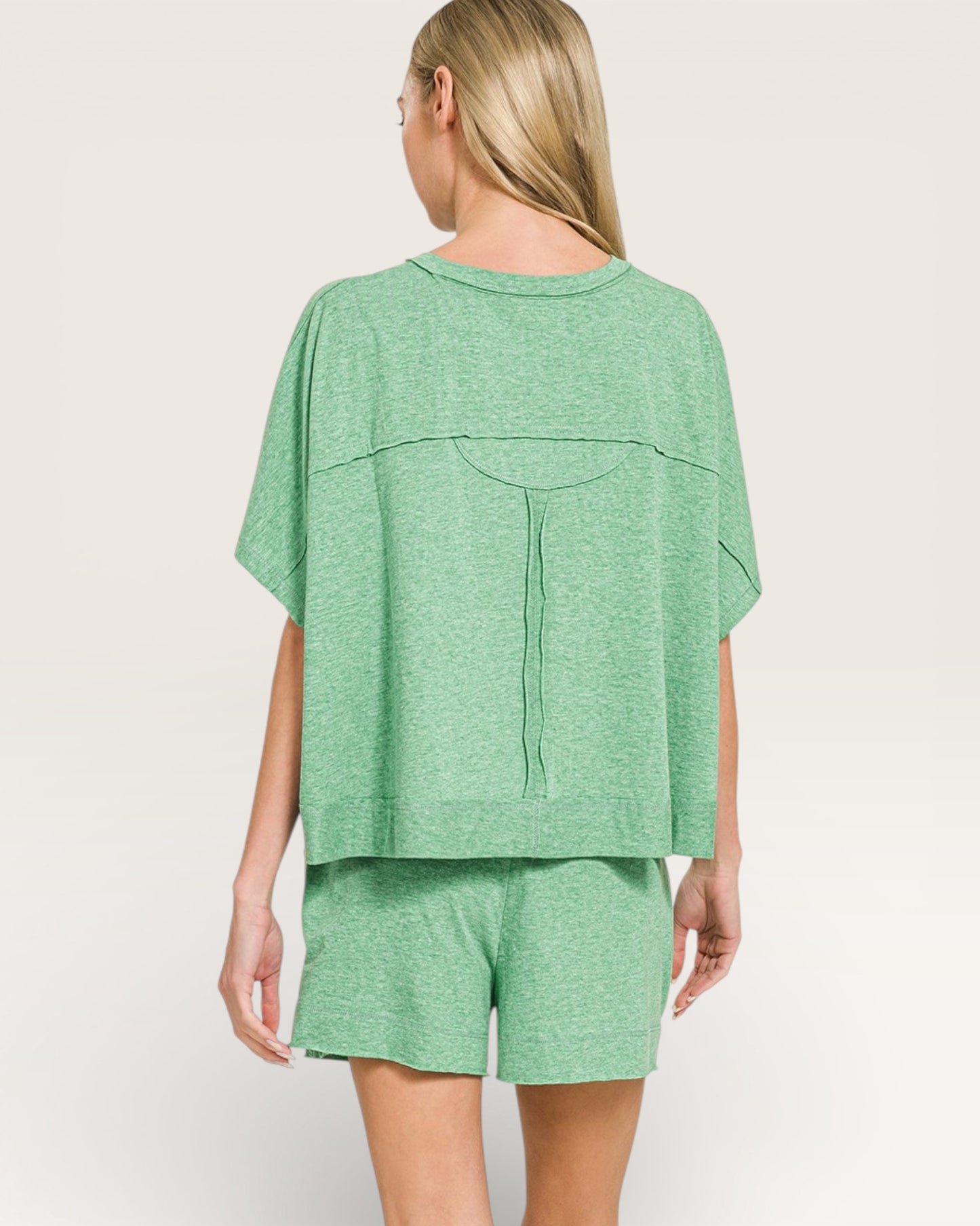 Woman wearing a green outfit on a plain background