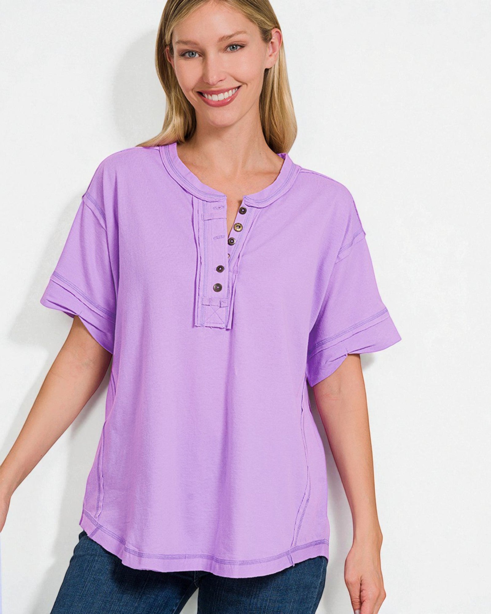 Woman wearing a purple short-sleeve shirt with buttons on a white background