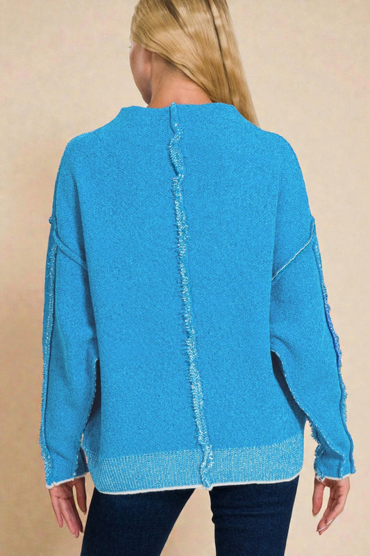 Blue sweater with a zigzag pattern on a beige background