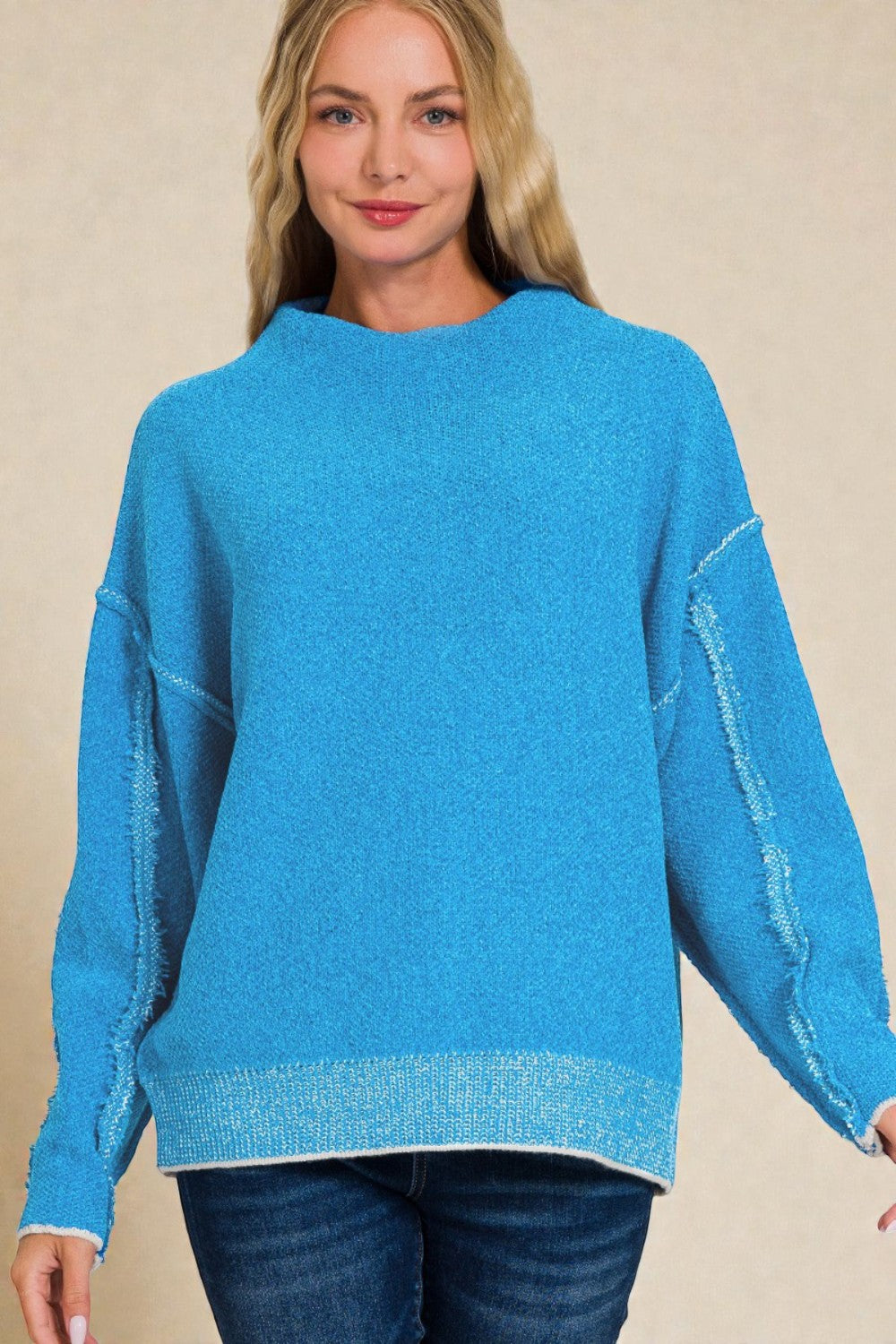 Woman wearing a blue sweater against a beige background