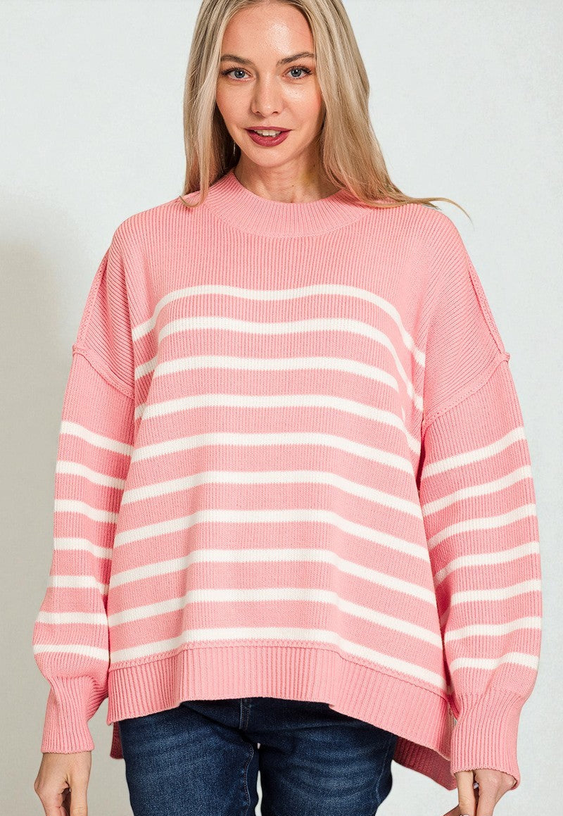 Woman wearing a pink and white striped sweater against a plain background