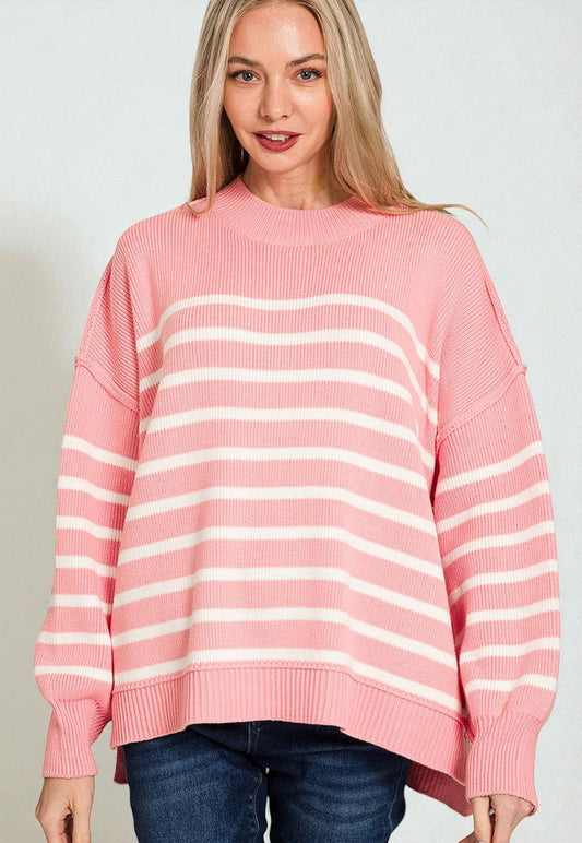 Woman wearing a pink and white striped sweater against a plain background