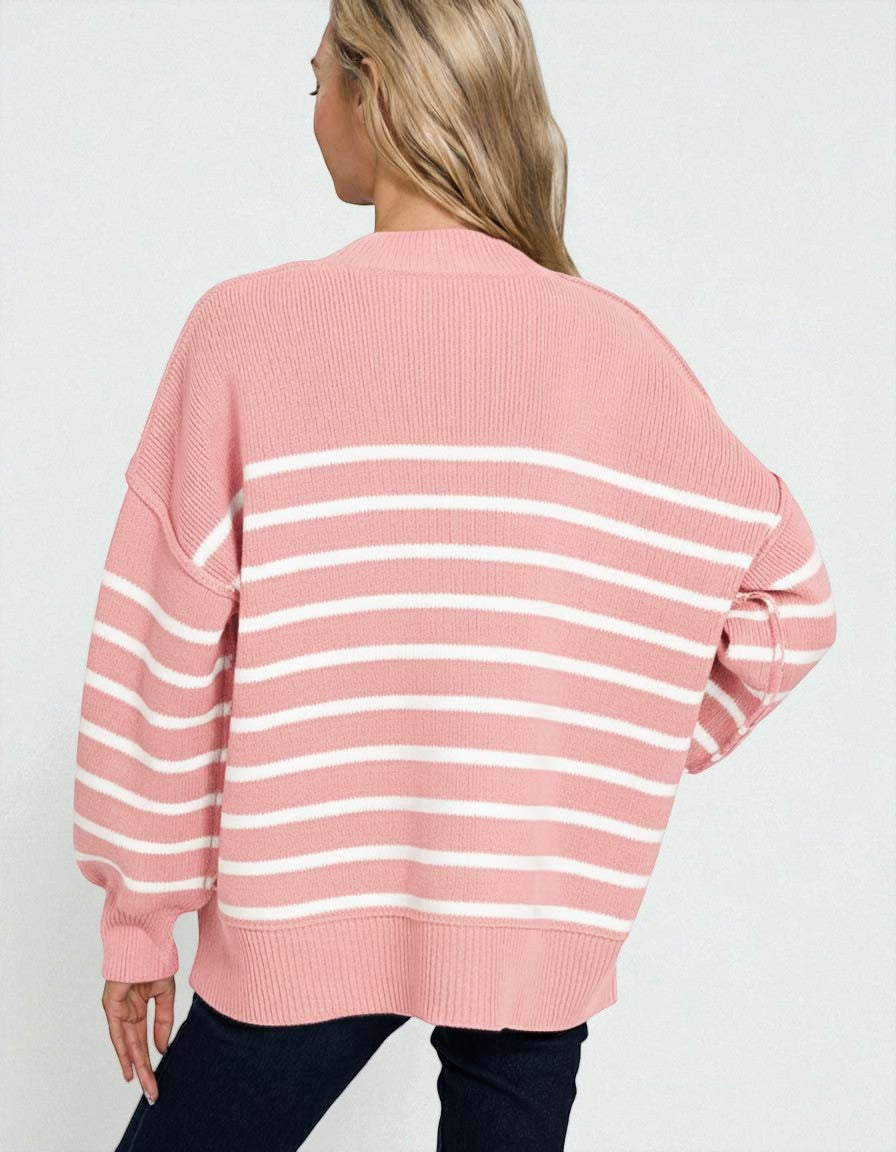Person wearing a pink and white striped sweater on a plain background