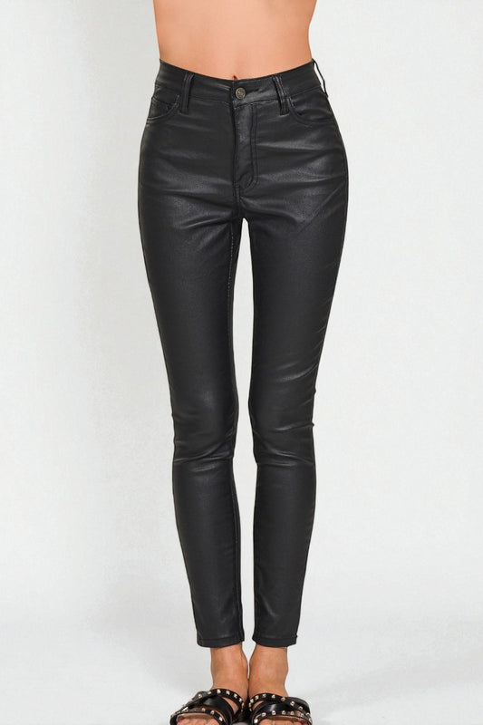 Black leather pants worn by a person on a white background