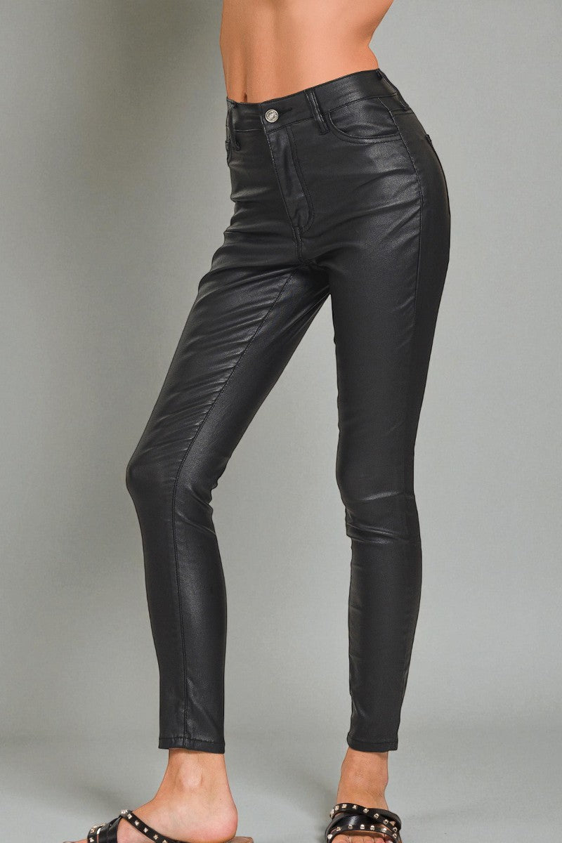 Black leather pants worn by a person on a gray background