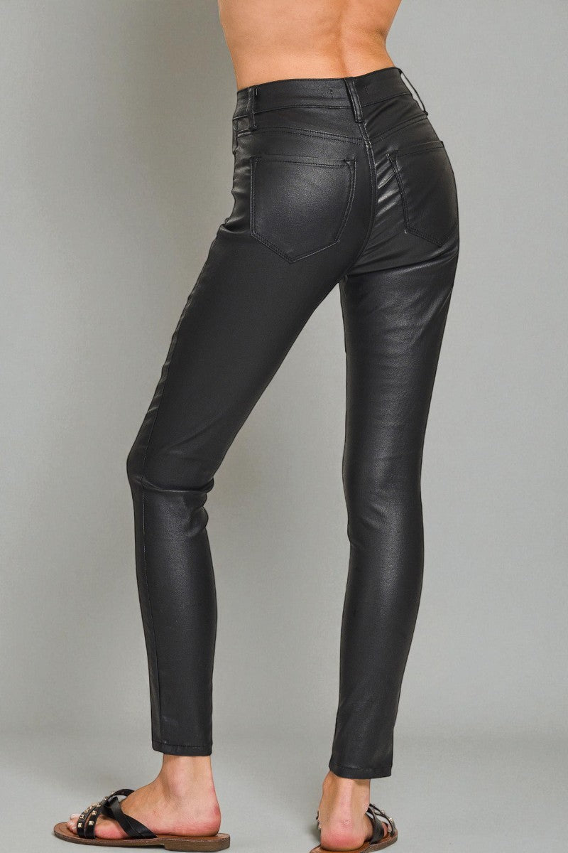 Black leather pants worn by a person on a gray background