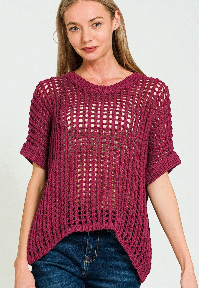 Woman wearing a maroon knitted sweater and blue jeans on a white background