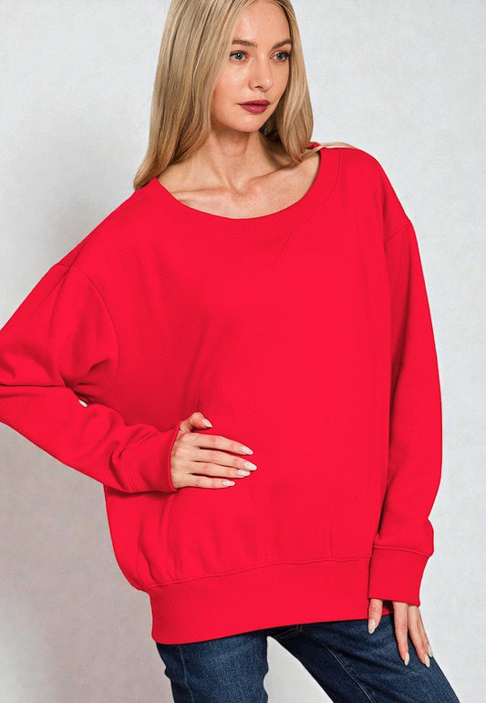 Woman wearing a red sweater against a plain background