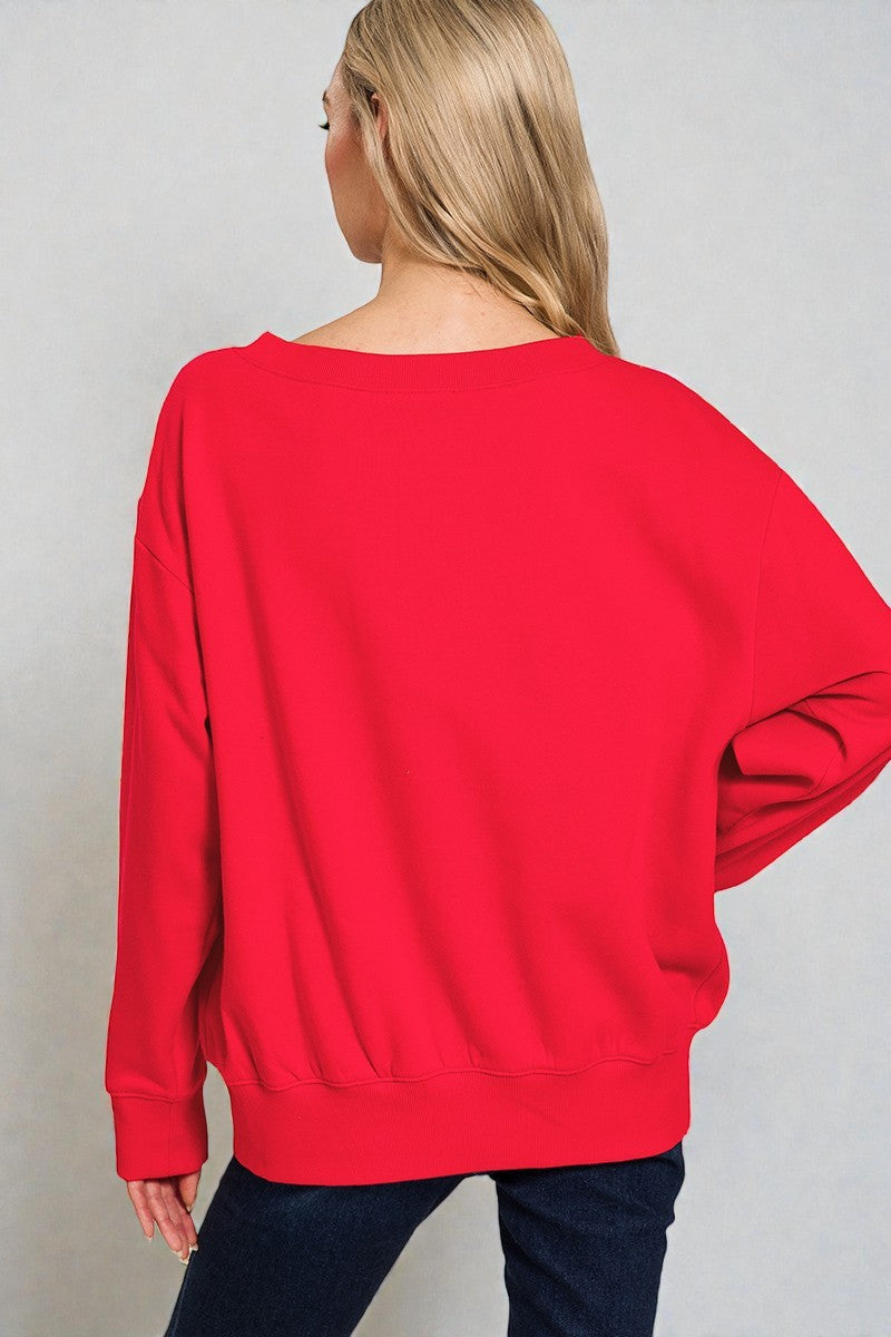 Person wearing a red sweater against a plain background