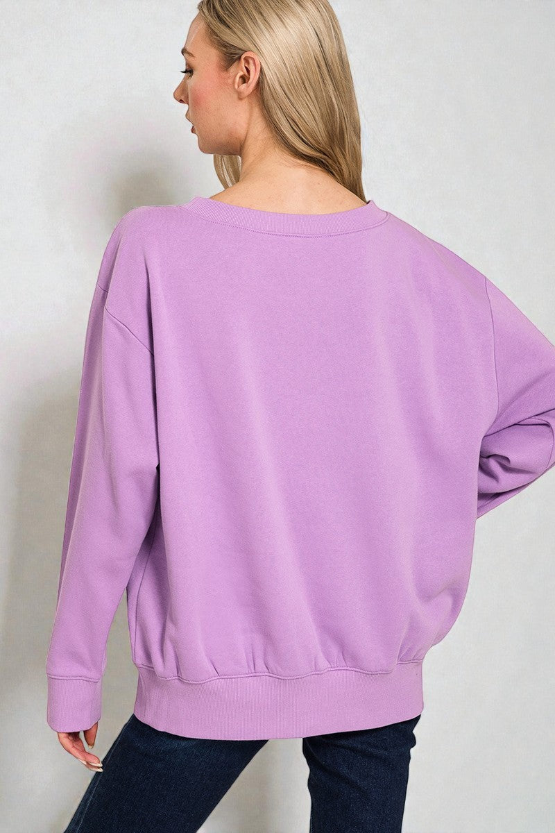 Person wearing a purple sweatshirt against a plain background