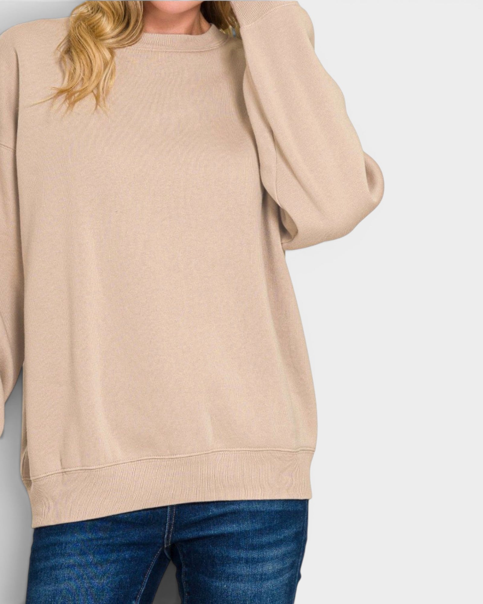 Beige sweatshirt worn by a person on a plain background