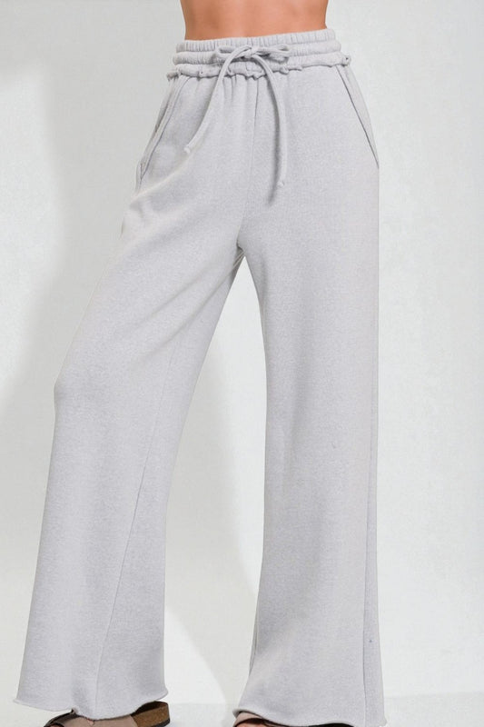 Light gray wide-leg pants with a drawstring waist on a white background
