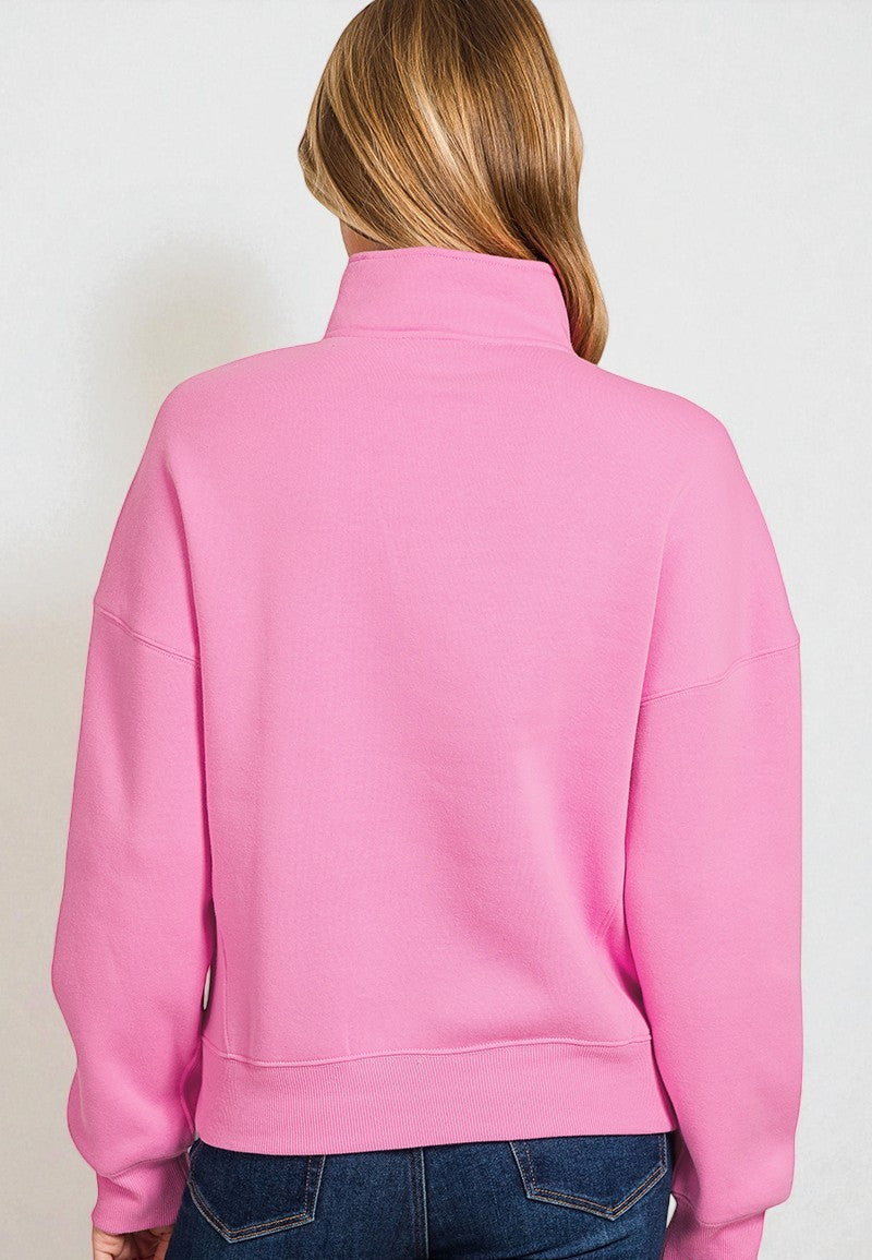 Person wearing a pink jacket on a plain background