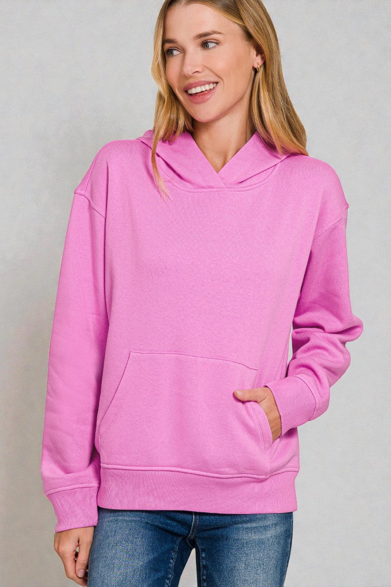 Woman wearing a pink hoodie against a plain background
