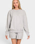 Woman wearing a gray sweatshirt and shorts set on a white background