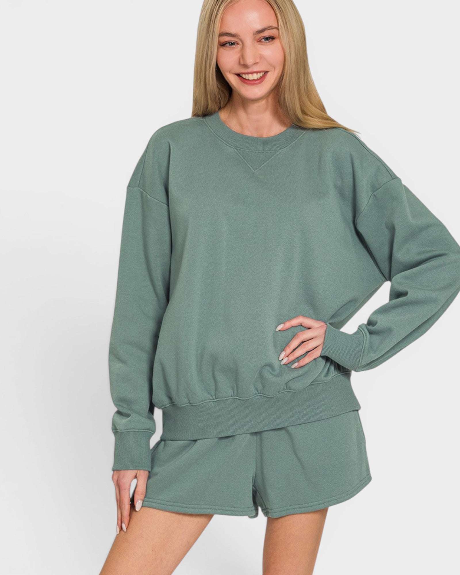 Woman wearing a green sweatshirt and shorts set on a white background