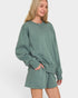 Woman wearing a green oversized sweatshirt and shorts set on a white background