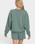 Person wearing a green sweatshirt and shorts set on a white background