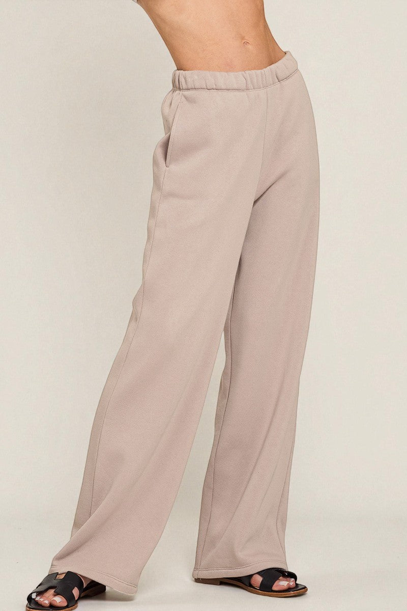 Beige wide-leg pants worn by a person on a plain background