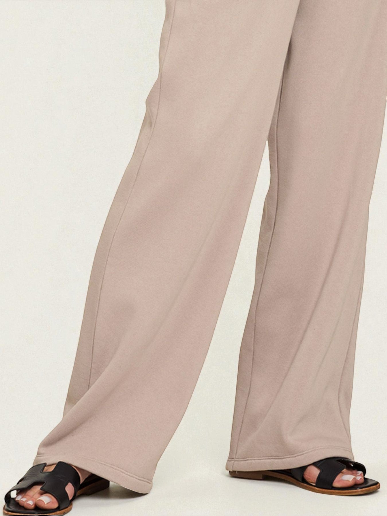 Beige wide-leg pants worn by a person on a white background