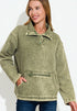 Woman wearing a green fleece pullover with a white background