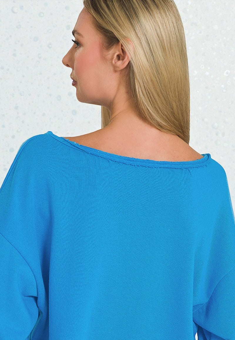 Woman wearing a blue top with a plain background
