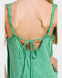 Green tank top with thin straps and open back on a plain background