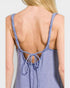 Purple tank top with thin straps and open back on a plain background