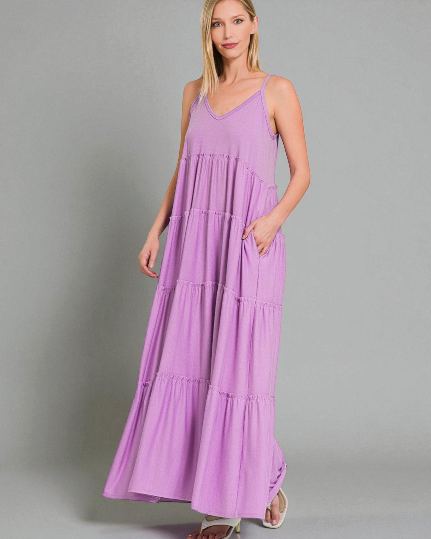 Woman wearing a purple maxi dress against a gray background
