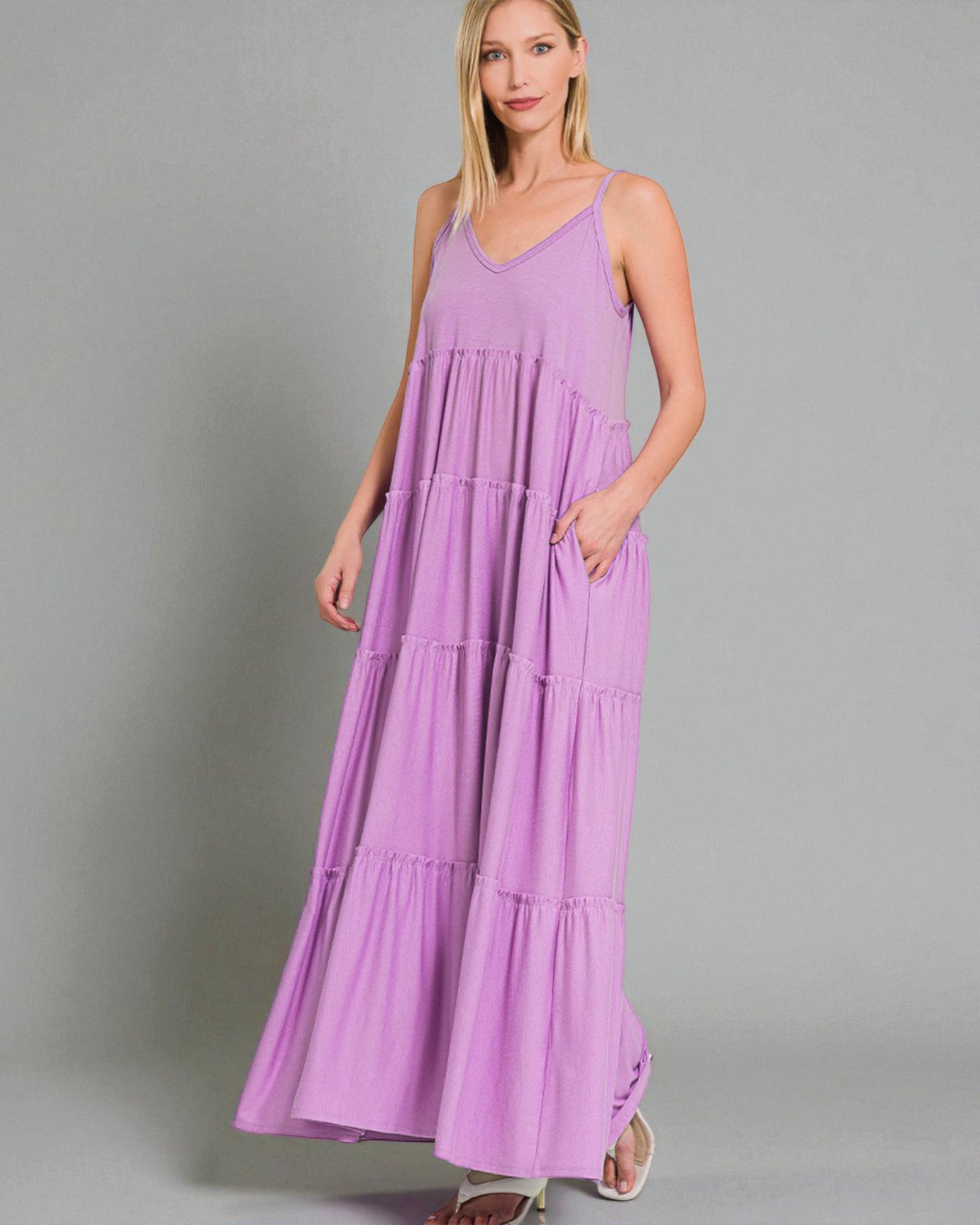 Woman wearing a purple maxi dress against a gray background