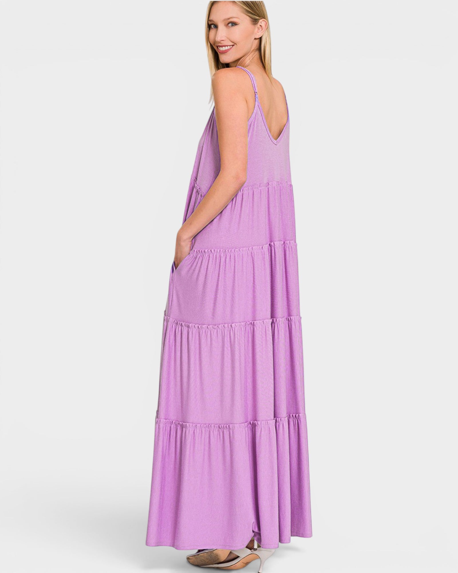 Woman wearing a purple tiered dress on a white background